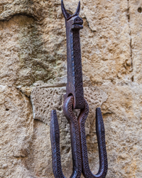 This iron bat stands guard over a narrow street in old Certaldo, Italy.