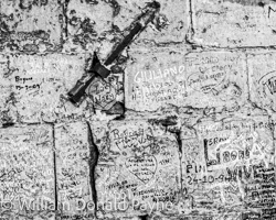 Signatures accumulate on an ancient Italian wall.