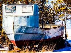 An old boat waits patiently, dreaming of fishing days long passed.